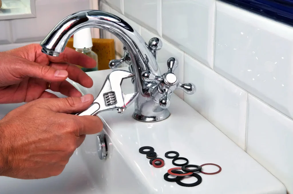 Plumber performing maintenance on a bathroom faucet in Louisville