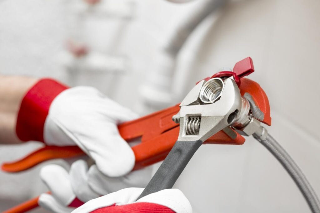 Plumber holding pipe wrenches for an emergency repair in Louisville